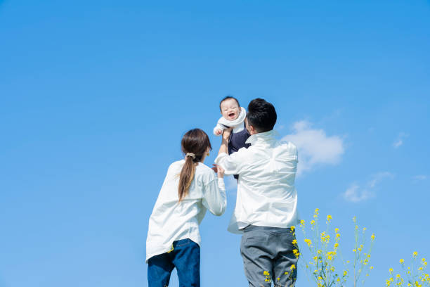 赤ちゃんをたかいたかいする夫婦