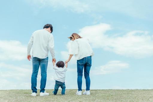 お父さんとお母さんが子供の手を繋いでいる